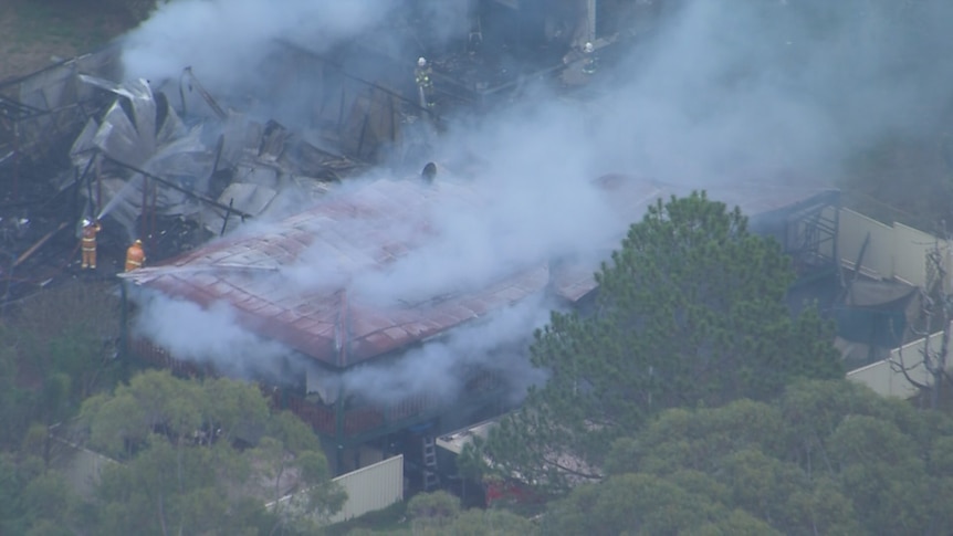 Firefighters work to extinguish a fire at a house on Russell Island in Queensland.