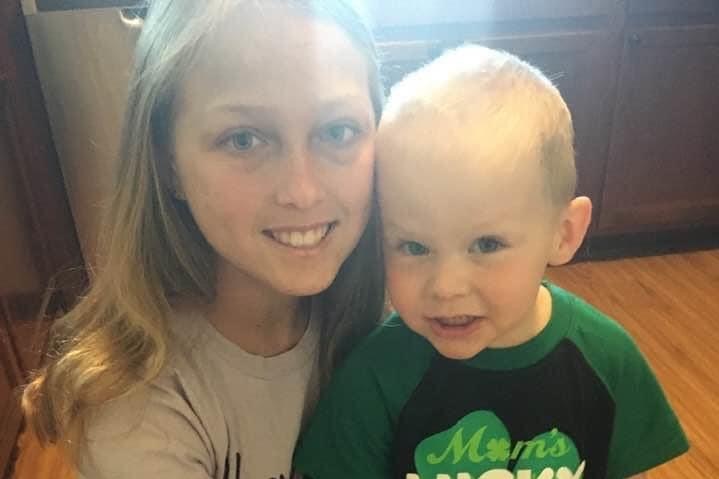 A girl poses for a photo with a toddler.