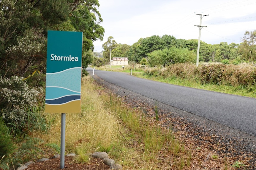 A sign on the side of a country road reads Stormlea