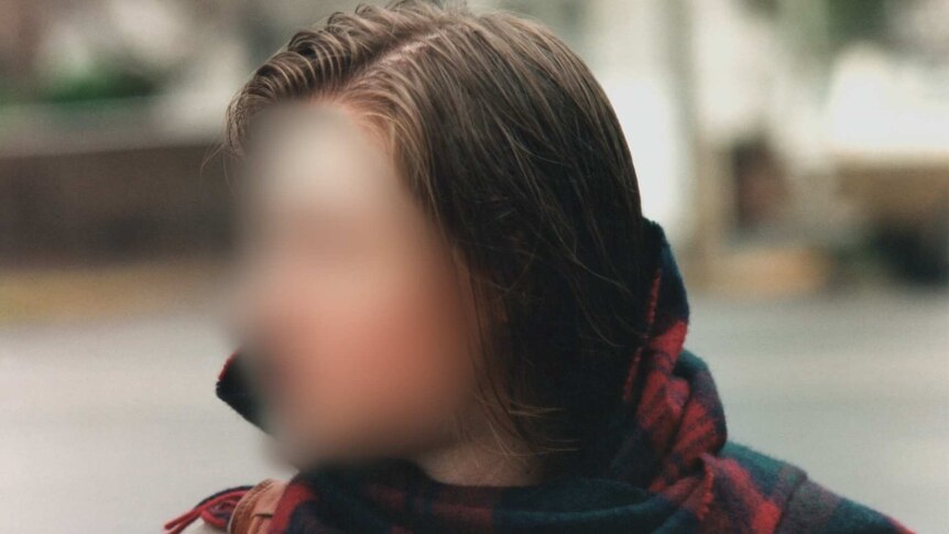 Blurred image of a woman wearing a scarf.
