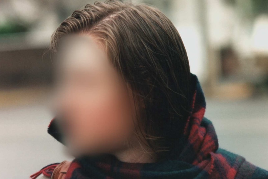 Blurred image of a woman wearing a scarf.