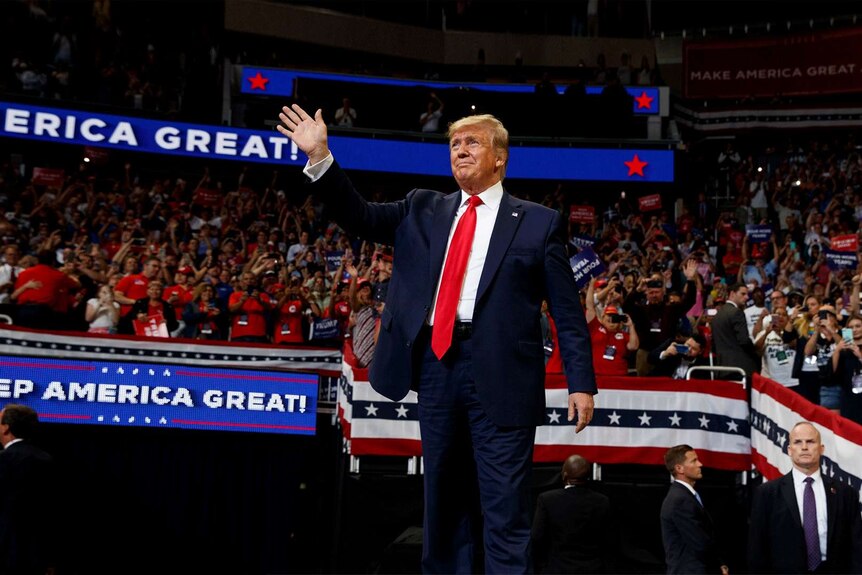 Donald Trump waves at a crowd at a rally