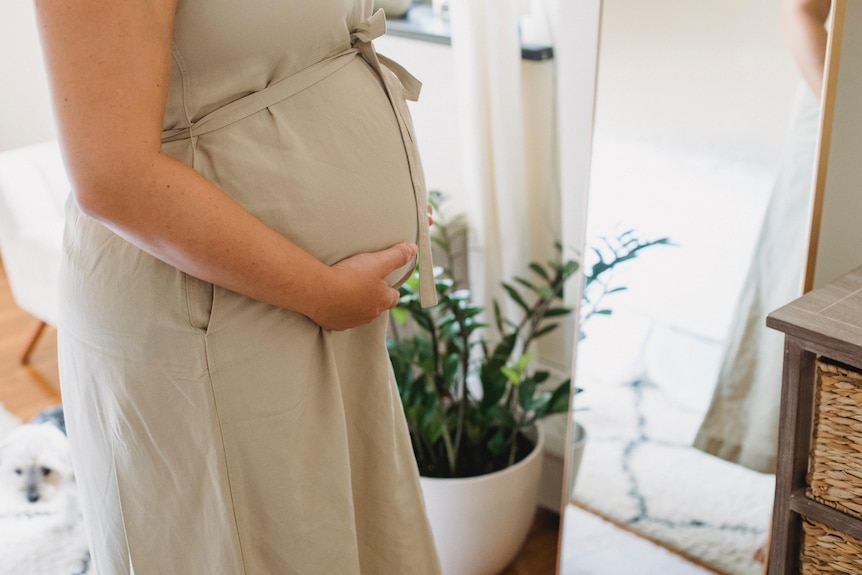 Woman with hand over baby bump