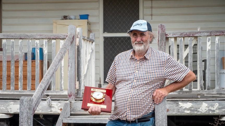 Warwick farmer Gerard Walsh at his farm house holding his award from the Bureau of Meteorology in February 2021.