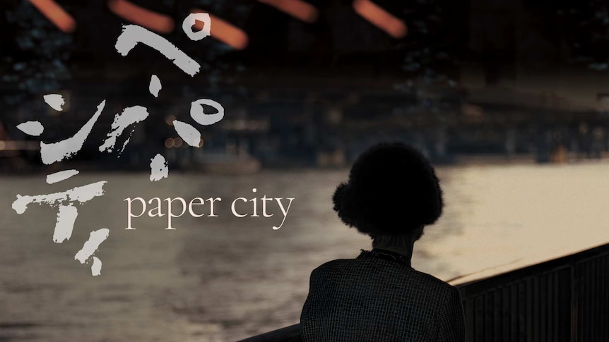 Paper City image of woman looking across a river