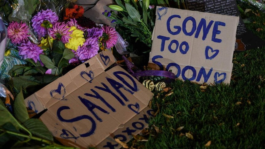 Flowers and cardboard signs saying "Sayyad" and "Gone too soon".
