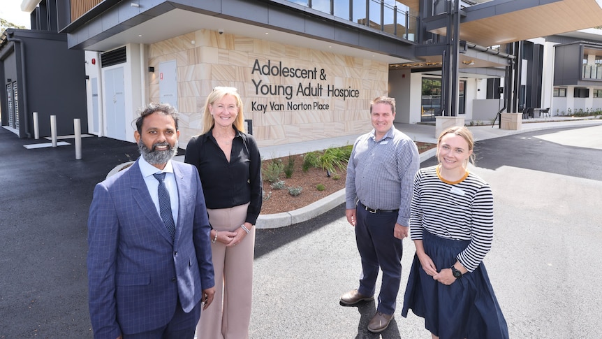 Staff of Australia's first youth-specific palliative care service stand outside a sign for the facility
