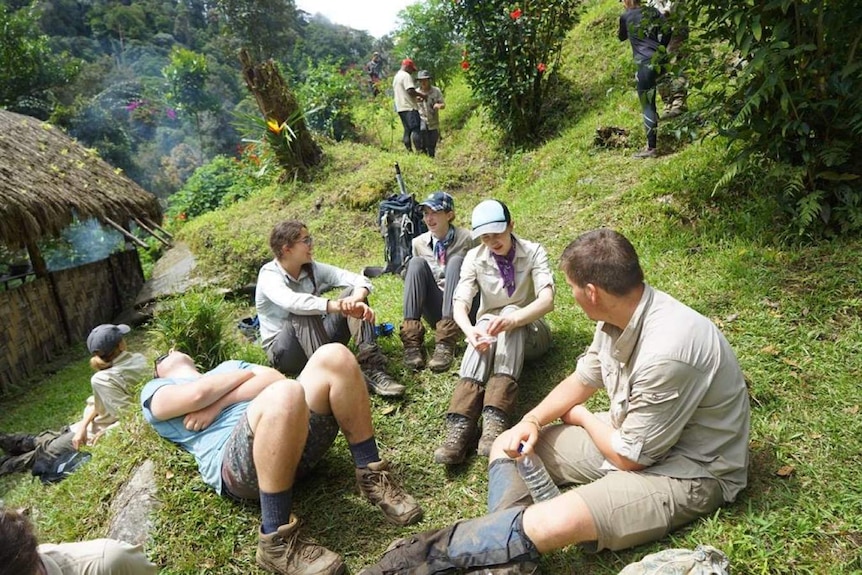 Group of hikers resting on hillside.