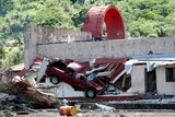 A damaged car lies in the wall of a building in Pago Pago on American Samoa