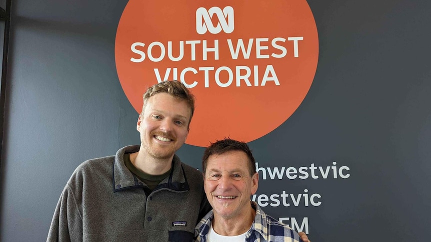 matt tribe stands with lazy lester in front of an abc south west victoria sign