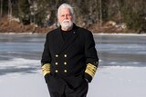 Paul Watson in captain's uniform stands on ice