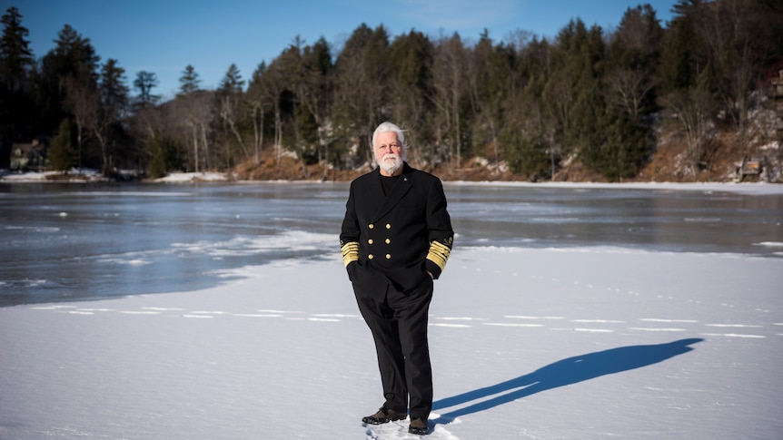 Paul Watson in captain's uniform stands on ice