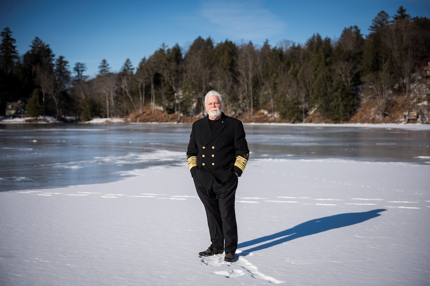 Paul Watson in captain's uniform stands on ice