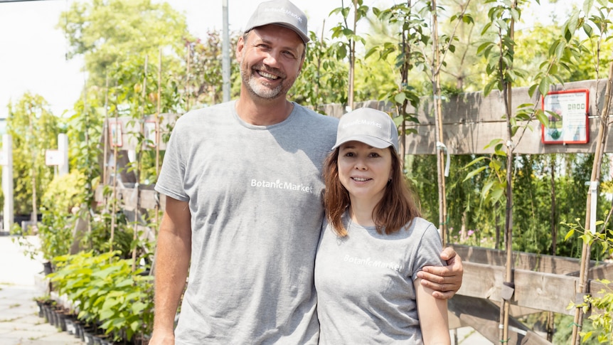 a tall man and a smaller woman smile while standing in a nursery.