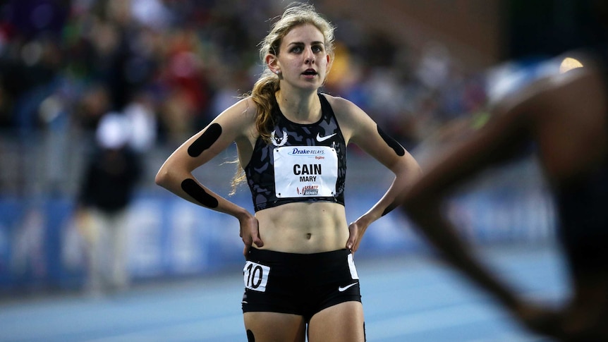 Mary Cain has her hands on her hips while standing on a race track.