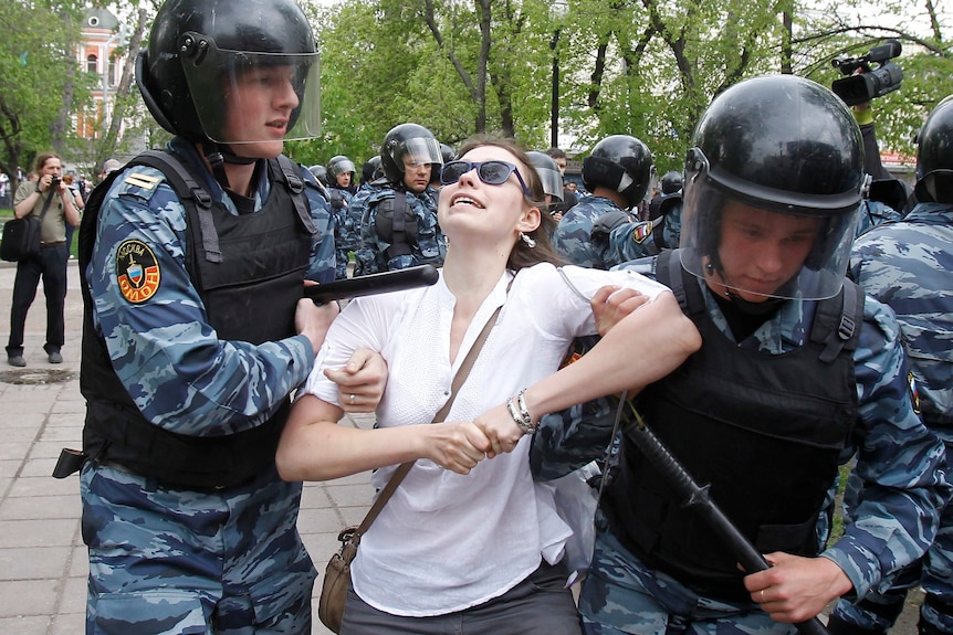 Riot police detain an opposition supporter in Moscow