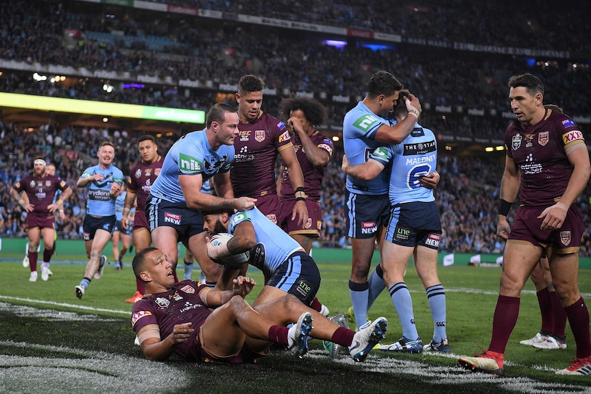 Josh Addo-Carr and teammates celebrate a Blues' try against Queensland