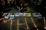 People gather during a candlelight vigil for the victims of Malaysia Airlines flight MH17, in Kuala Lumpur