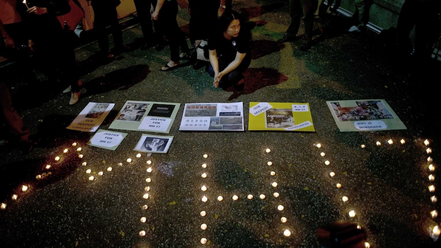 People gather during a candlelight vigil for the victims of Malaysia Airlines flight MH17, in Kuala Lumpur