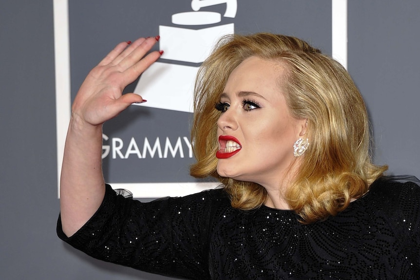 Adele plays up for the cameras on the Grammys red carpet