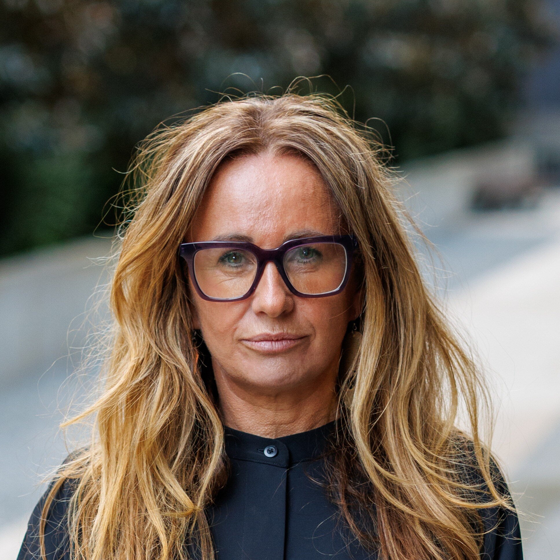 Commissioner Hunter has blonde wavy hair and black reading glasses