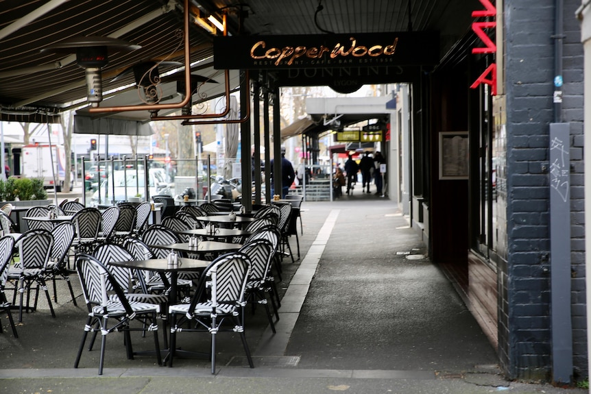 Empty chairs and tables outside a cafe.