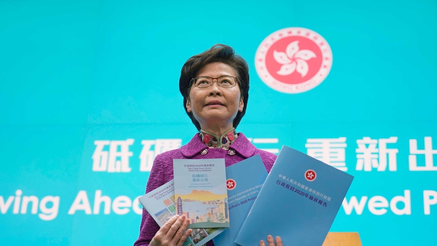 Hong Kong Chief Executive Carrie Lam poses with copies of her policy address