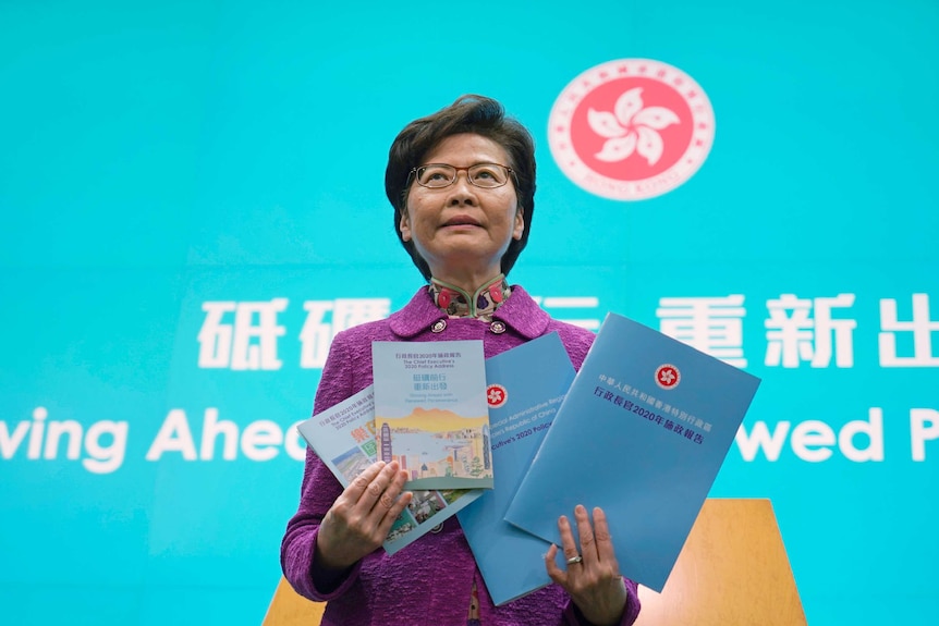 Hong Kong Chief Executive Carrie Lam poses with copies of her policy address
