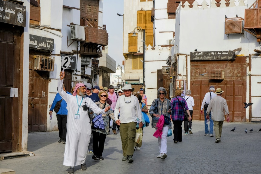 Tourists are guided through the streets of a historical area of Jeddah known as the old town.