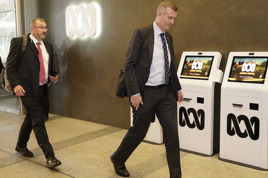 Two men in suits enter the ABC.