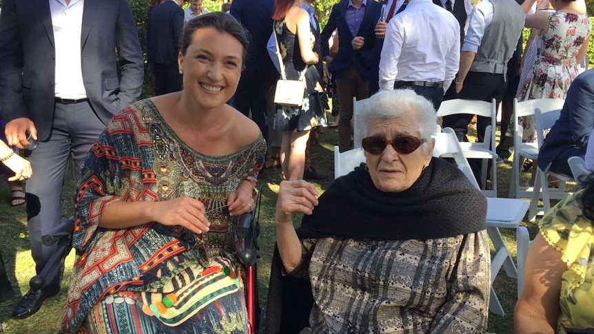 A woman siting next to her nonna at a wedding.