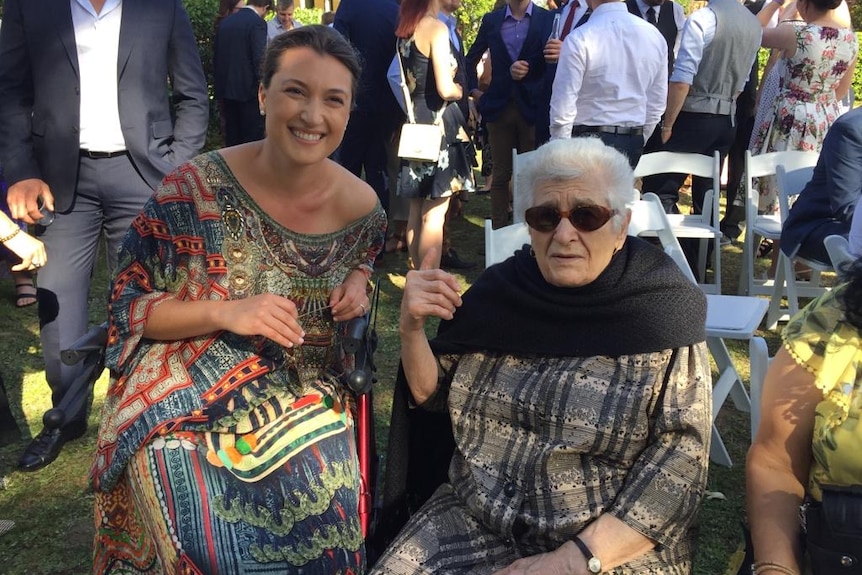 A woman siting next to her nonna at a wedding.