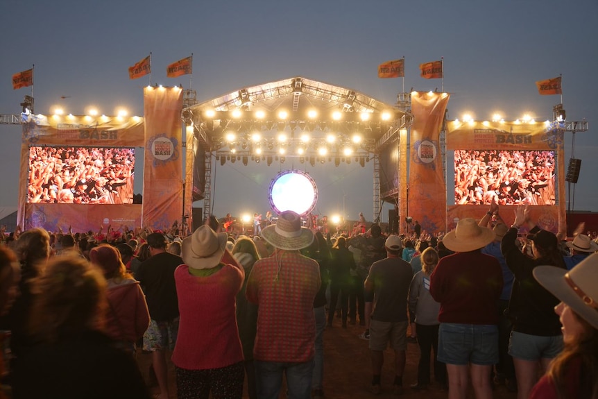 A crowd looks at a stage at night at the Mundi Mundi Bash music festival.