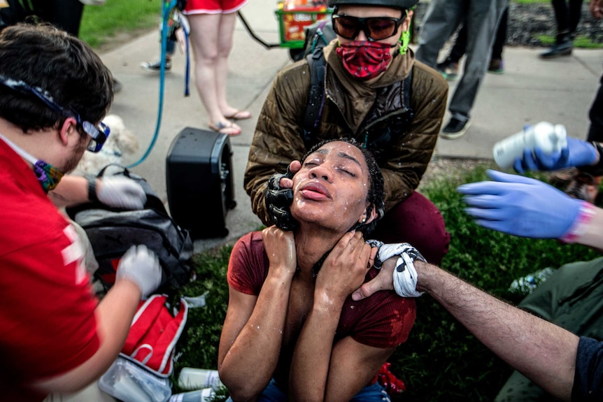 A woman has her face doused in milk