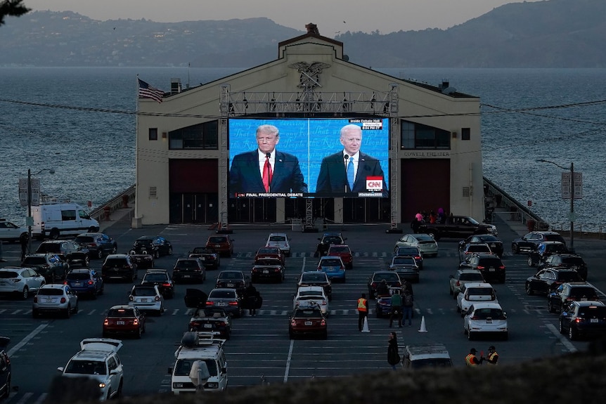 People watch from their vehicles as President Donald Trump and Democratic presidential candidate Joe Biden debate.