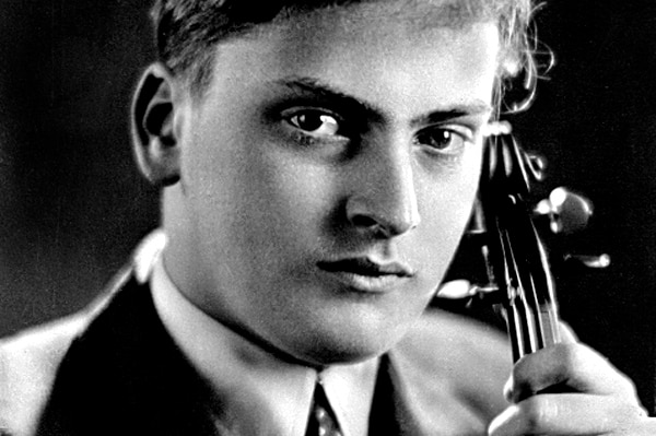 A black and white photograph of Yehudi Menuhin holding his violin taken in 1937.