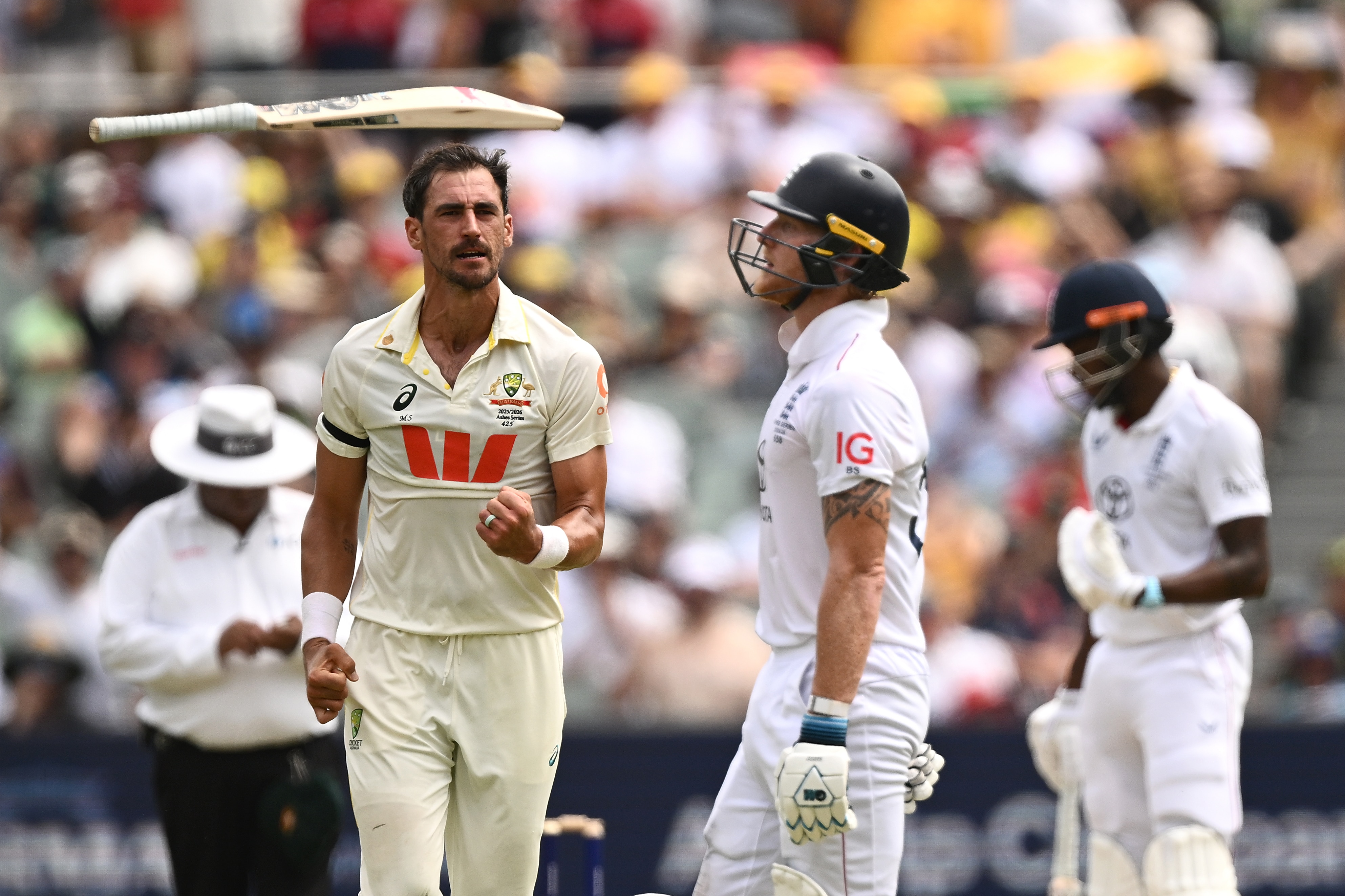 Mitchell Starc comemora o postigo de Ben Stokes enquanto joga seu taco para o alto.