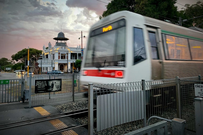 A passing train crosses a pedestrian walkway