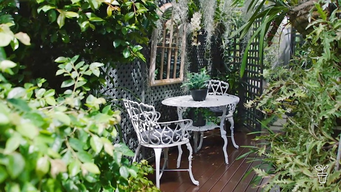 A courtyard garden with a white table and two chairs
