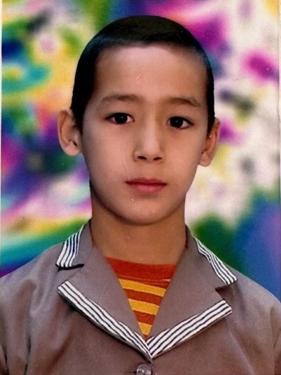 A young boy smiles at the camera