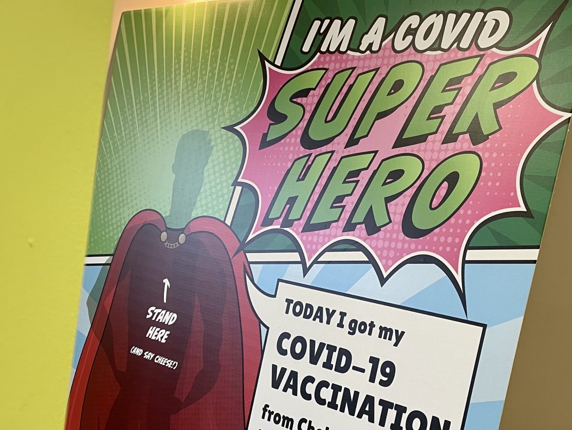 A pop-art styled poster reads 'COVID SUPER HERO: Today I got my COVID-19 vaccination".