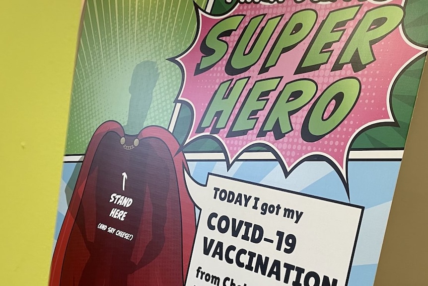 A pop-art styled poster reads 'COVID SUPER HERO: Today I got my COVID-19 vaccination".