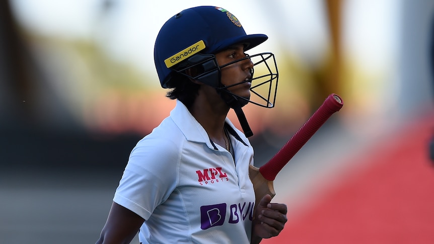 Indian batter Punam Raut tucks he bat under her arm and walks off the field during the Test against Australia.