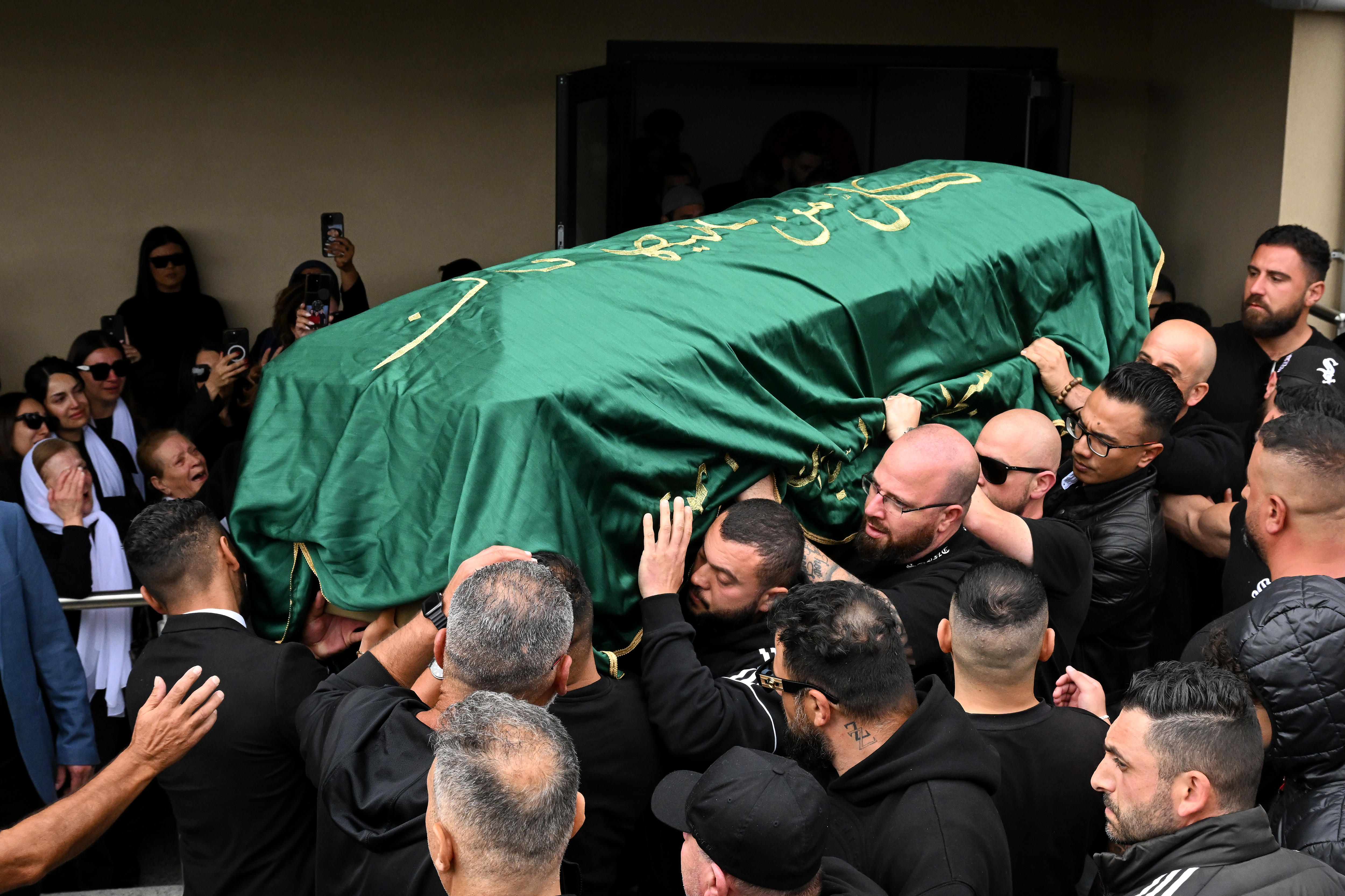 Pallbearers carry a coffin