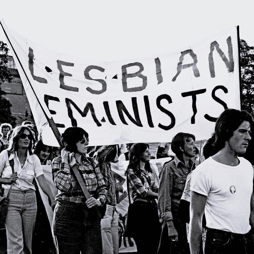 Lesbian feminists, including Robyn Kennedy, holding up a sign in 1976