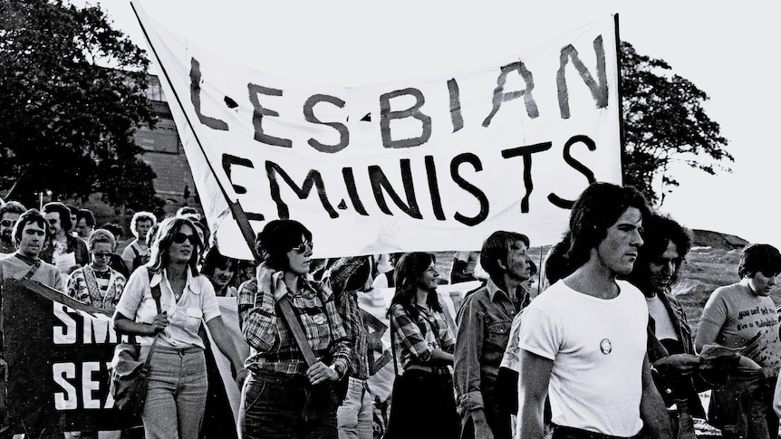 Lesbian feminists, including Robyn Kennedy, holding up a sign in 1976