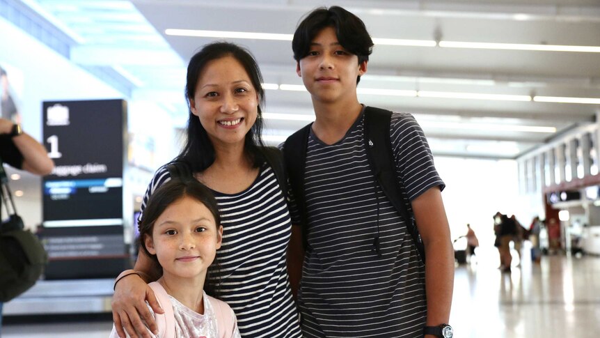 Catherine stands with her arms around her daughter and son.