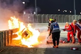 Marshals use a hose to try to put out a fire burning fiercely in a F1 car in Bahrain.