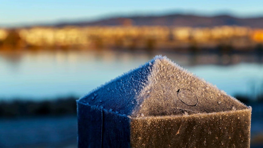 Frost builds up on a fence post