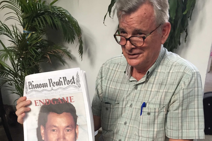 Founder of the Phnom Penh Post, Michael Hayes, holds up a 1997 copy of the paper.